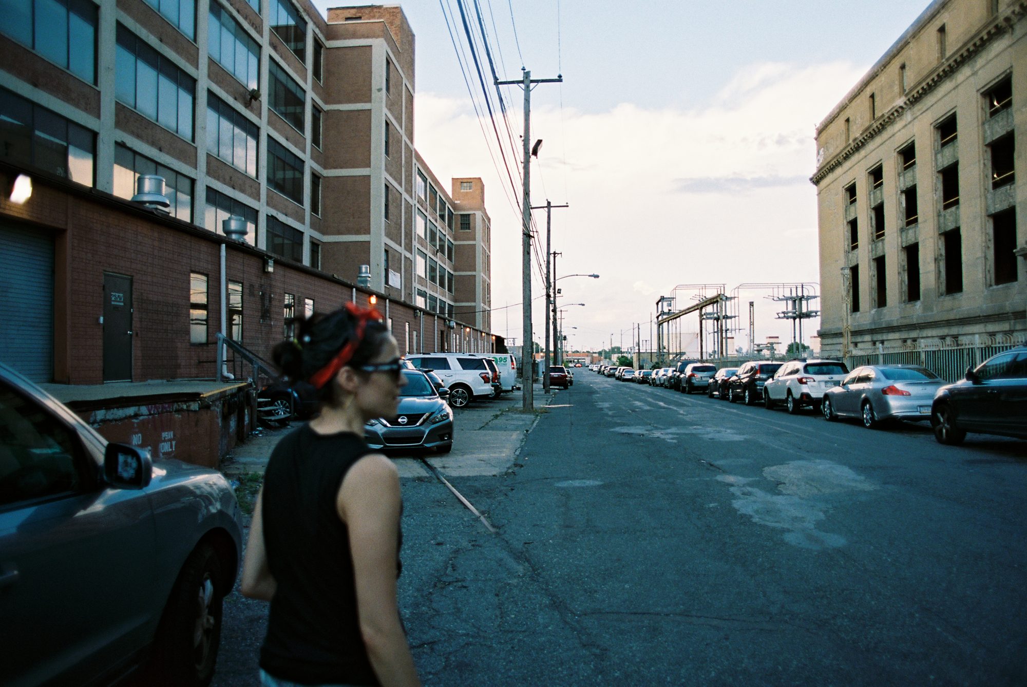 A woman walking down an industrial Philadelphia street